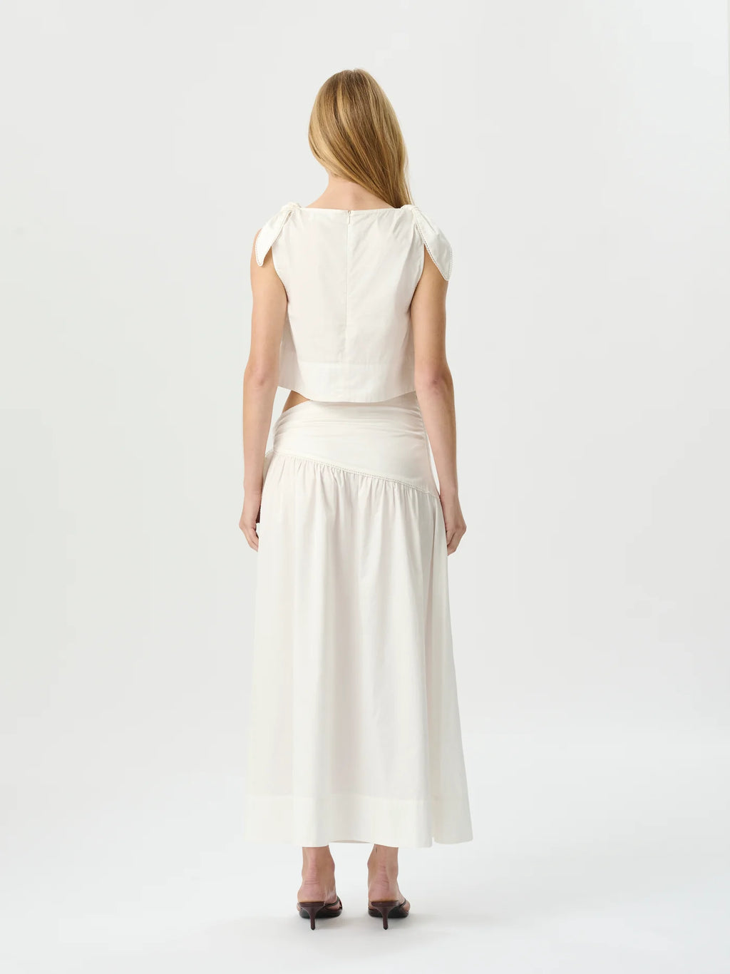 Woman wearing a white dress with a plain background