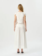 Woman wearing a white dress with a plain background