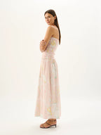 Woman wearing a strapless floral dress on a white background