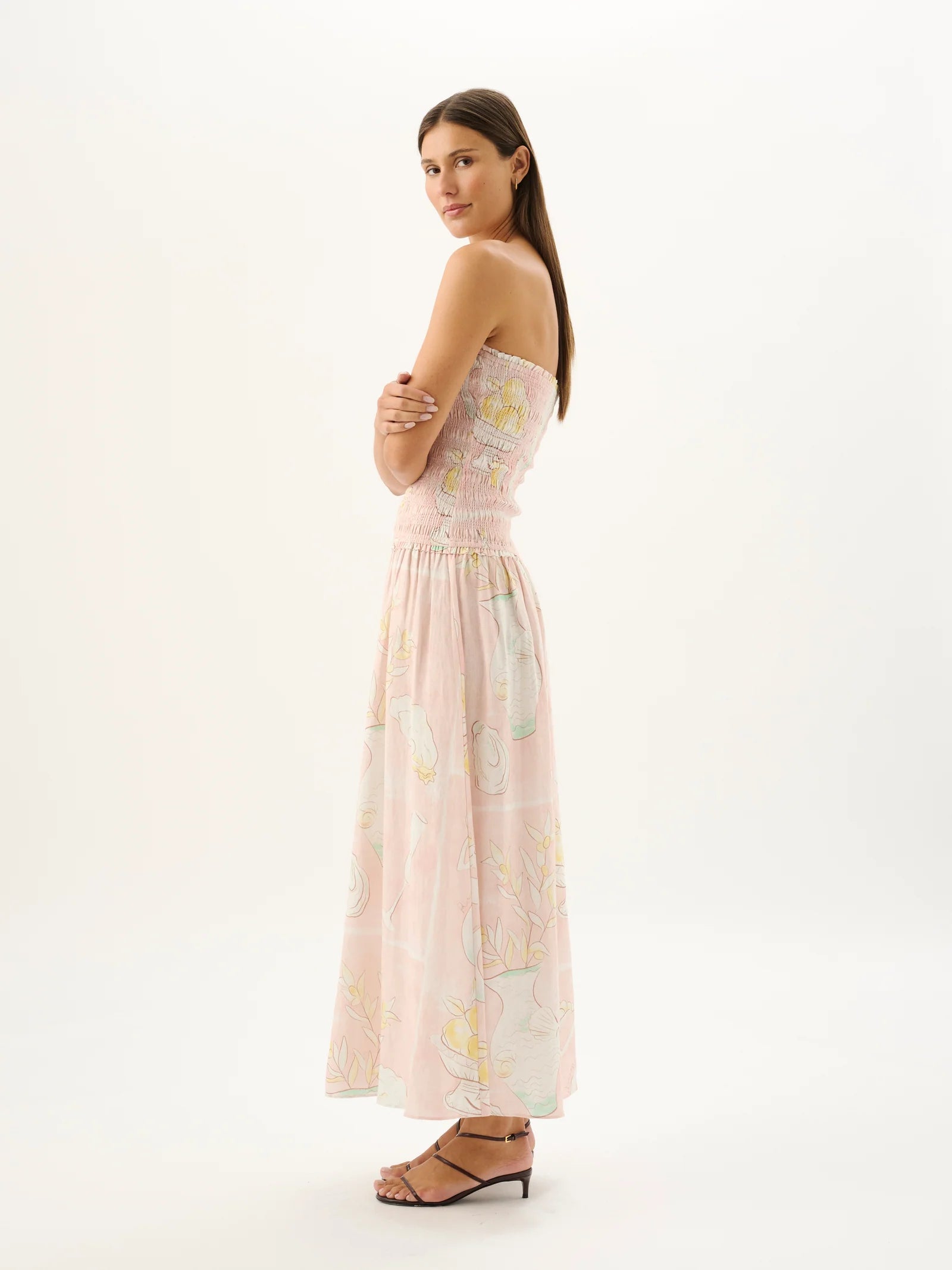 Woman wearing a strapless floral dress on a white background
