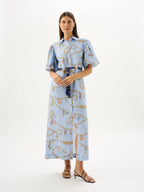 Woman wearing a light blue dress with a pattern on a white background