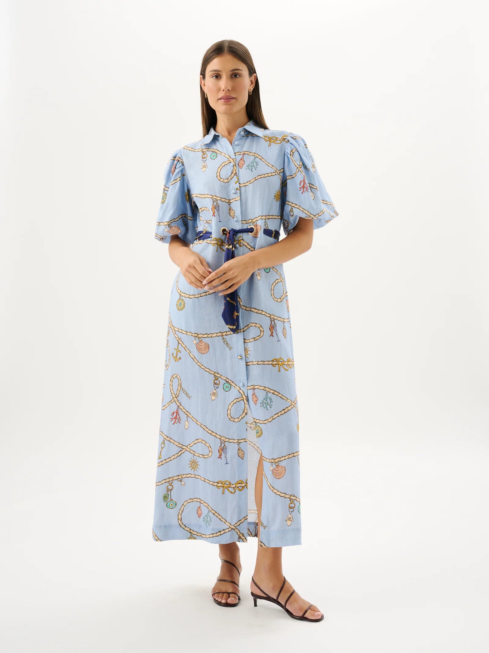 Woman wearing a light blue dress with a pattern on a white background