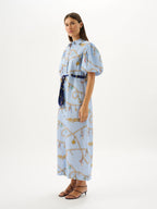 Woman wearing a light blue dress with a pattern on a white background