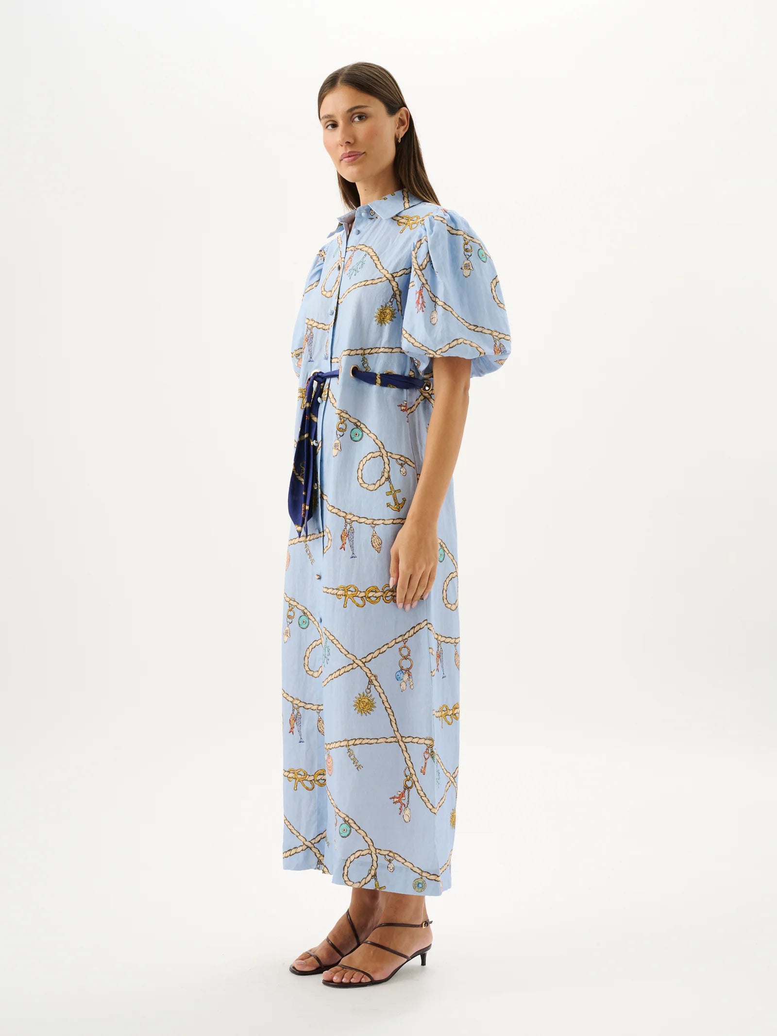 Woman wearing a light blue dress with a pattern on a white background