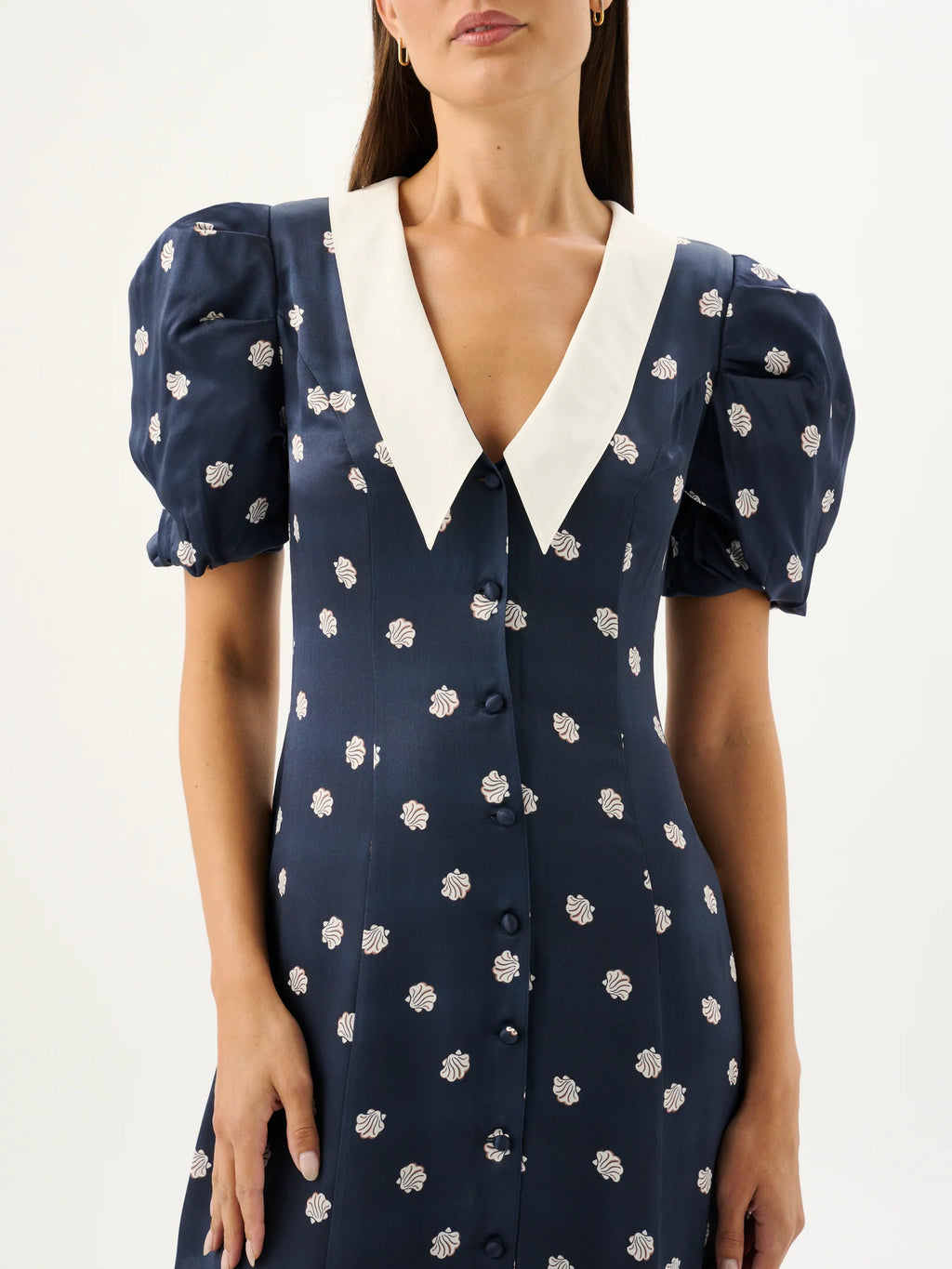 Navy dress with white floral pattern and white collar on a white background