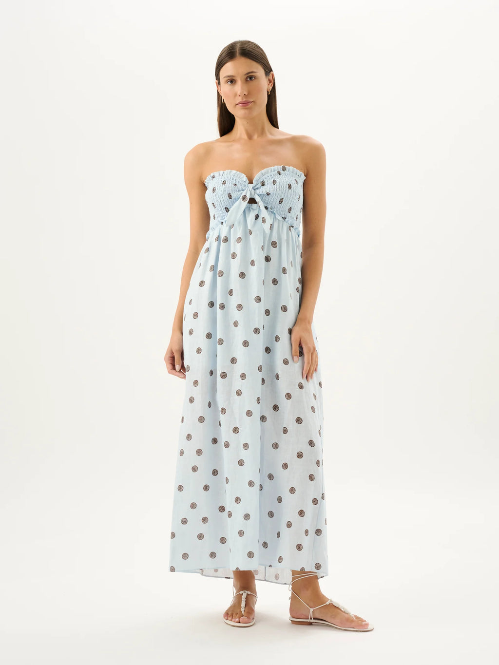 Woman wearing a strapless polka dot dress on a white background