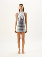 Woman wearing a striped dress with a sailor collar on a white background