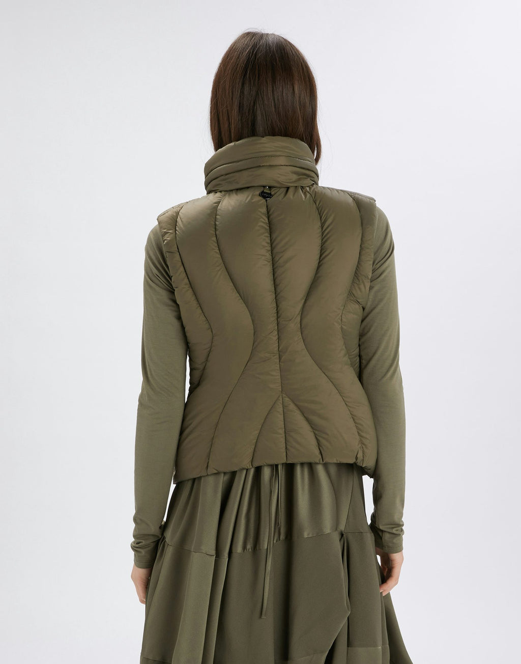 Person wearing a green jacket and skirt set on a white background