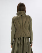 Person wearing a green jacket and skirt set on a white background