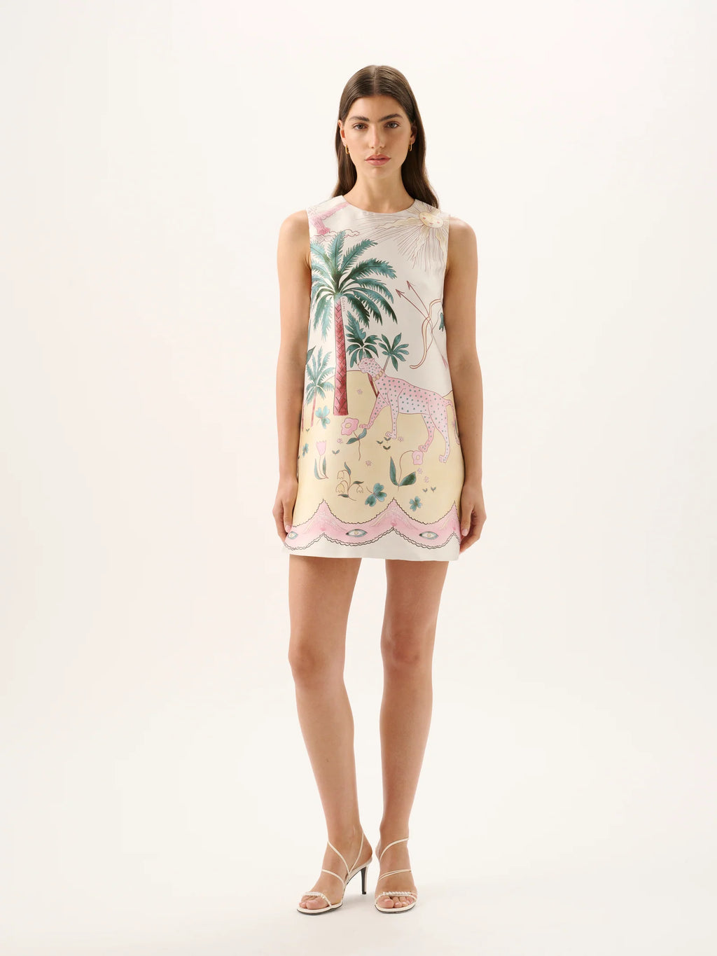 Woman wearing a sleeveless dress with palm tree and flamingo design on a white background