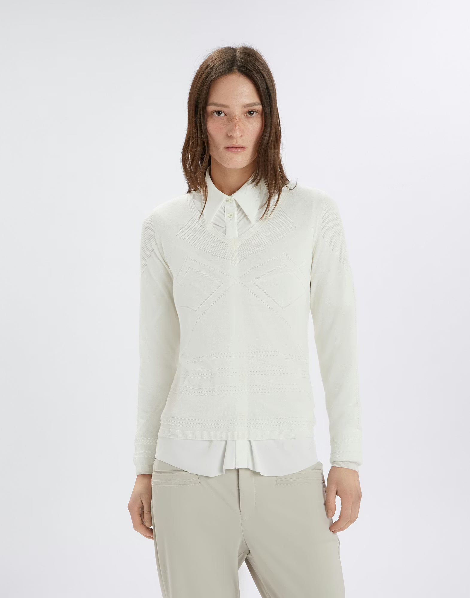 Woman wearing a white shirt and beige pants on a white background
