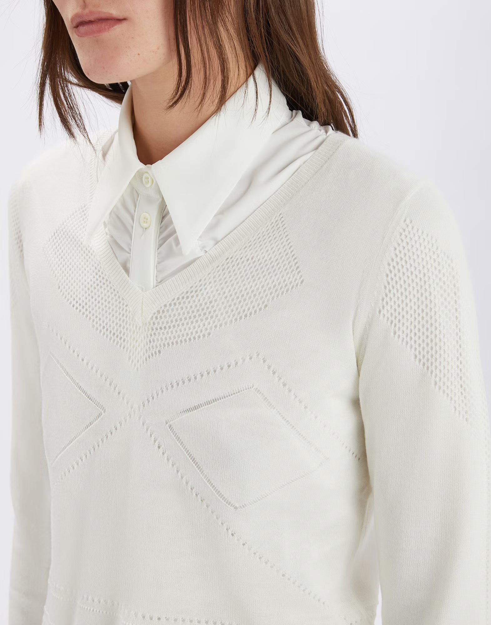 White textured sweater worn by a person on a white background