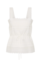 An off-white eyelet cotton camisole top with wide shoulder straps, a square neckline, horizontal gathered detailing, a drawstring tie at the waist, and a scalloped eyelet hem.