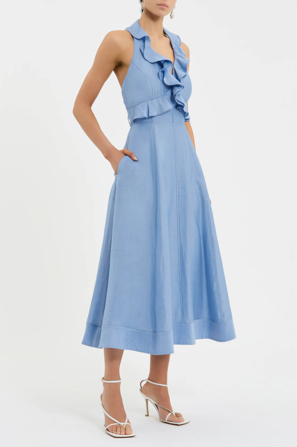 Woman wearing a light blue dress with ruffled top on a white background