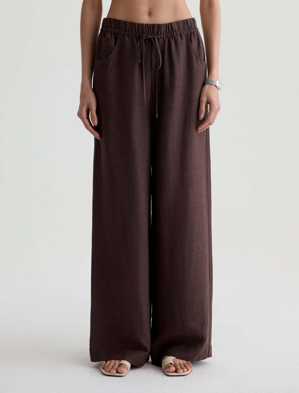 Brown wide-leg pants worn by a person on a white background