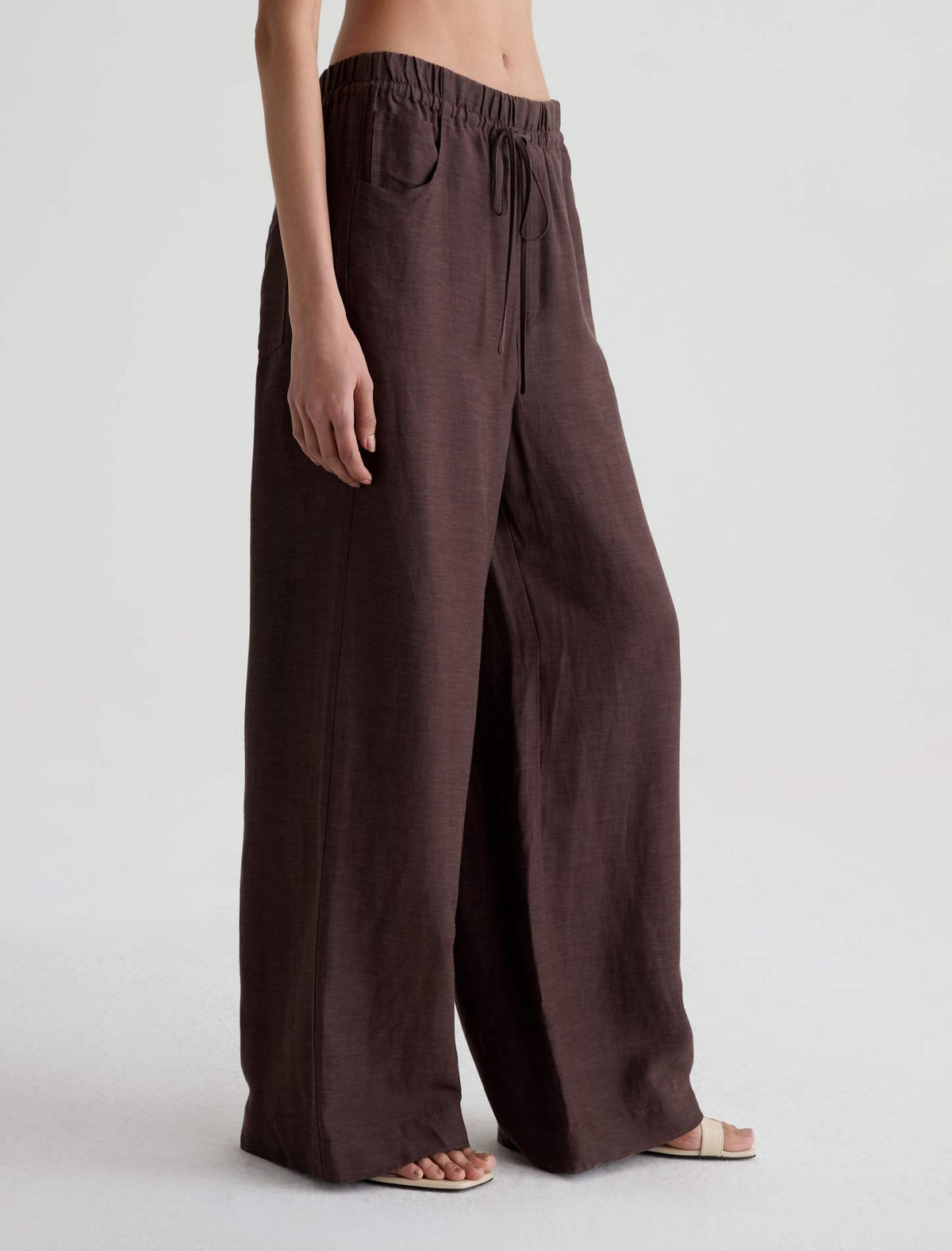 Brown wide-leg pants worn by a person on a white background
