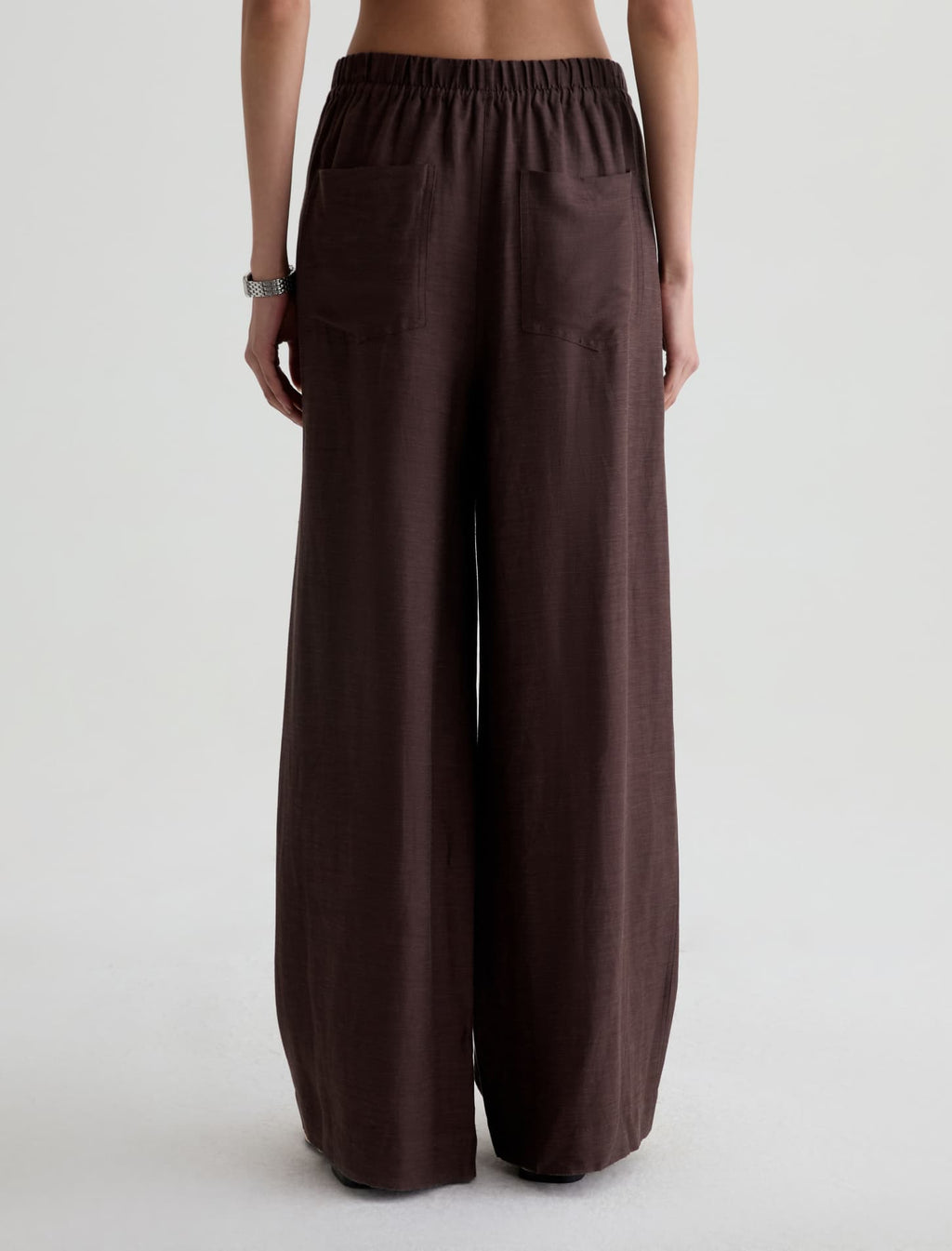 Brown wide-leg pants worn by a person on a white background