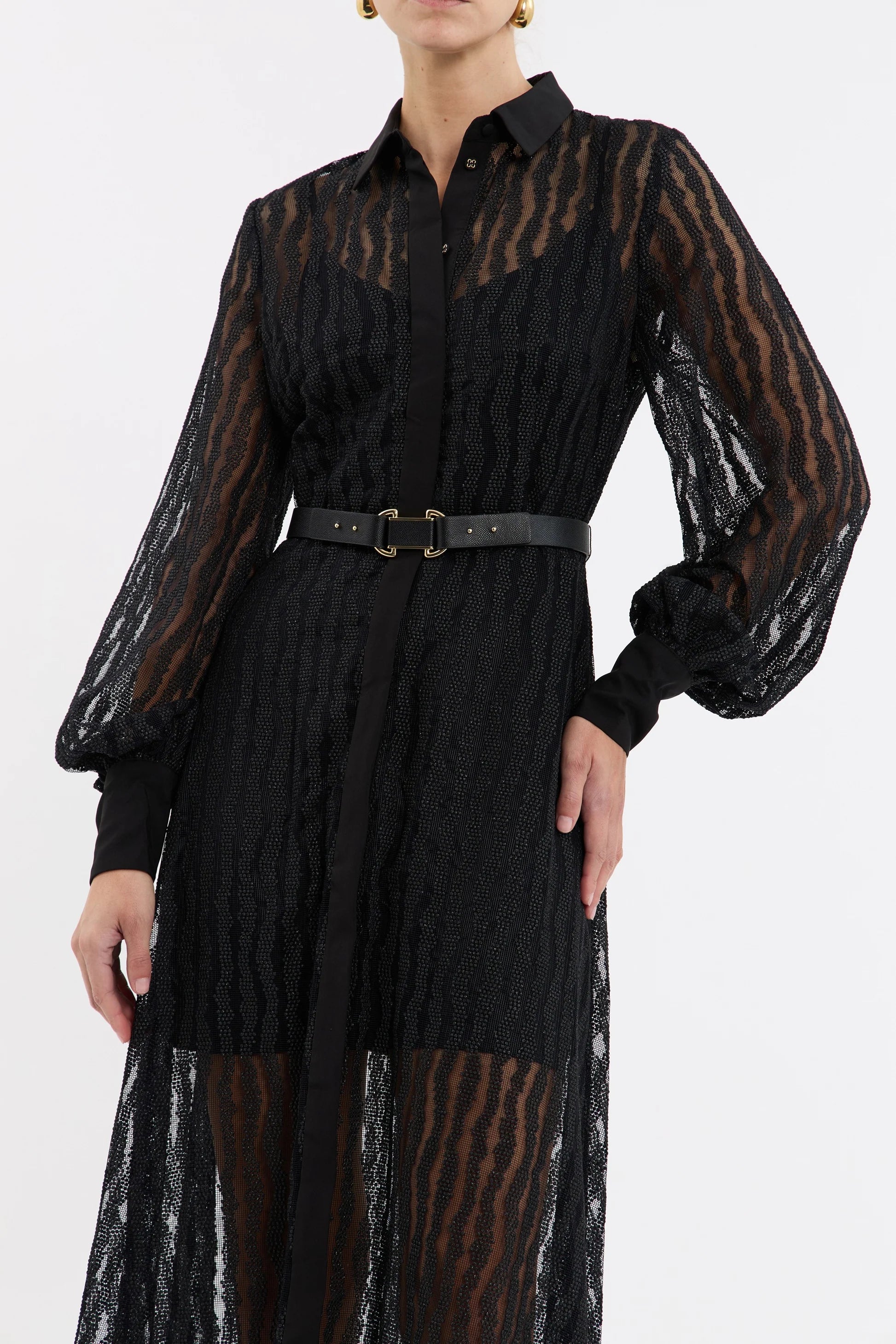 Black dress with sheer sleeves and belt on a white background