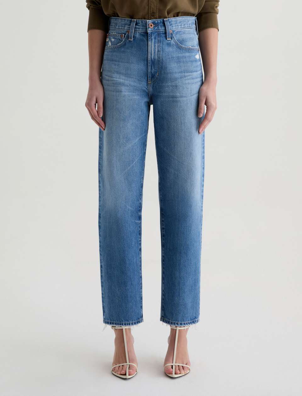 Person wearing blue jeans on a plain background