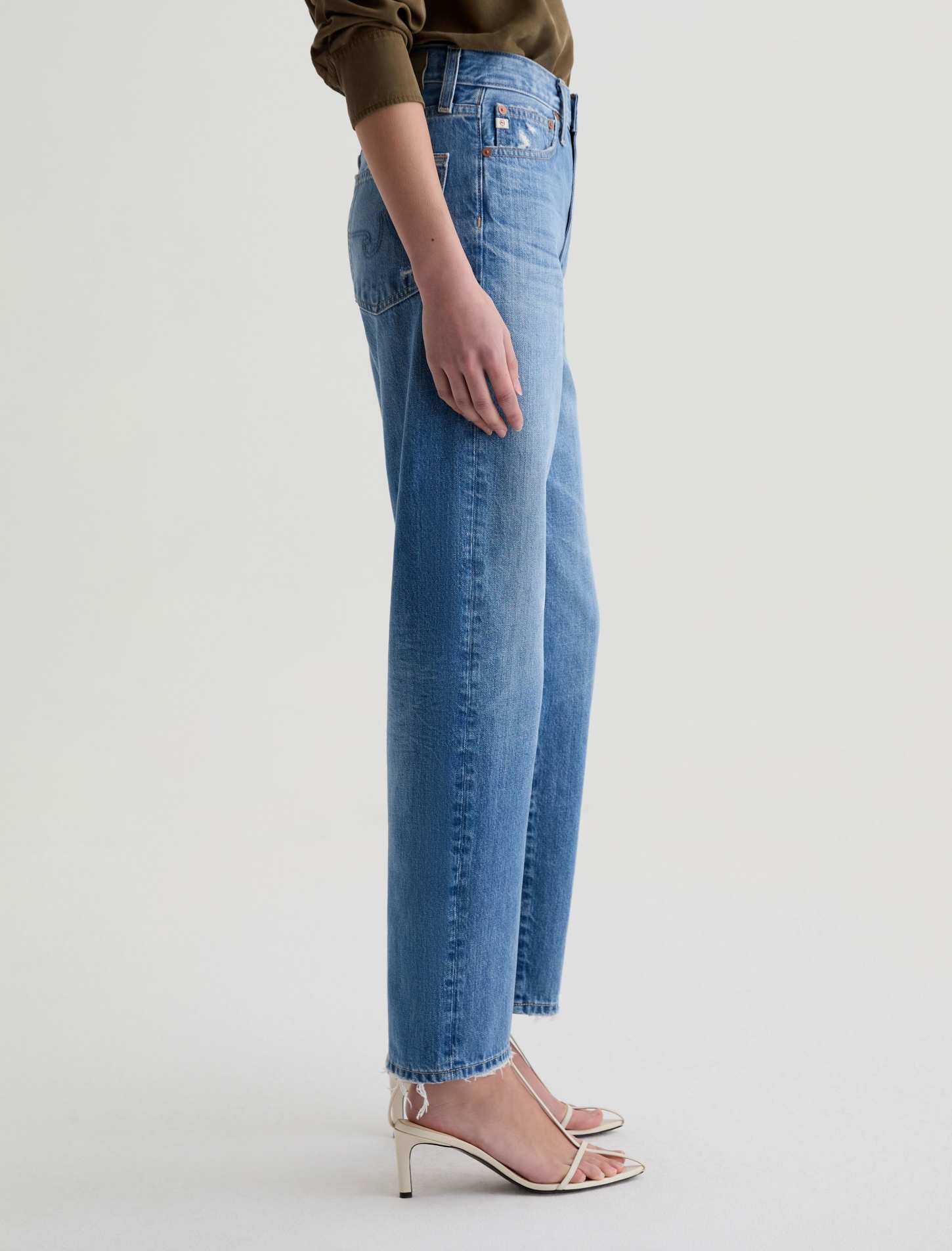 Blue jeans worn by a person on a light gray background