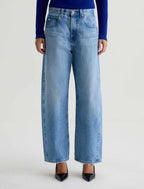 Person wearing light blue jeans on a white background