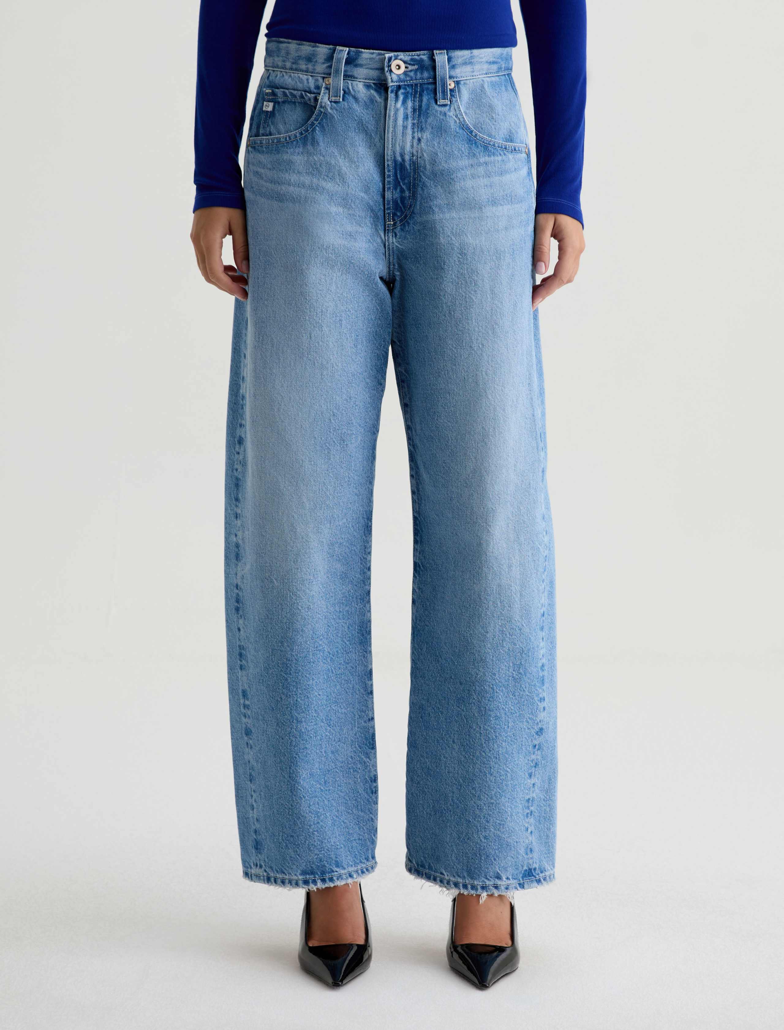 Person wearing light blue jeans on a white background