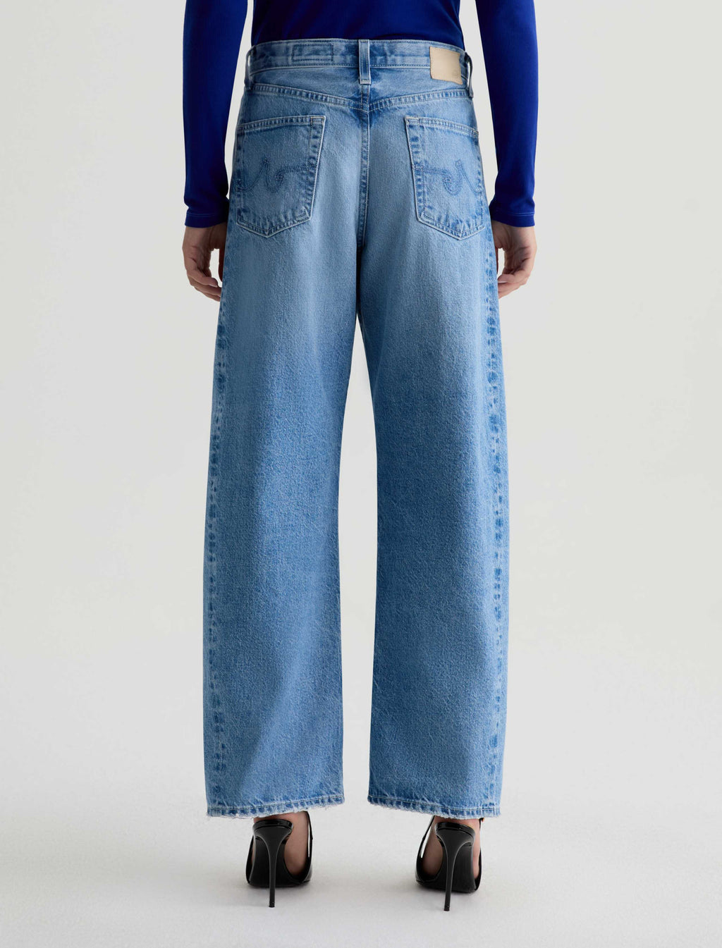 Person wearing blue jeans on a white background