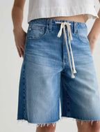Blue denim shorts with a white drawstring on a plain background