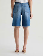 Person wearing blue denim shorts on a white background