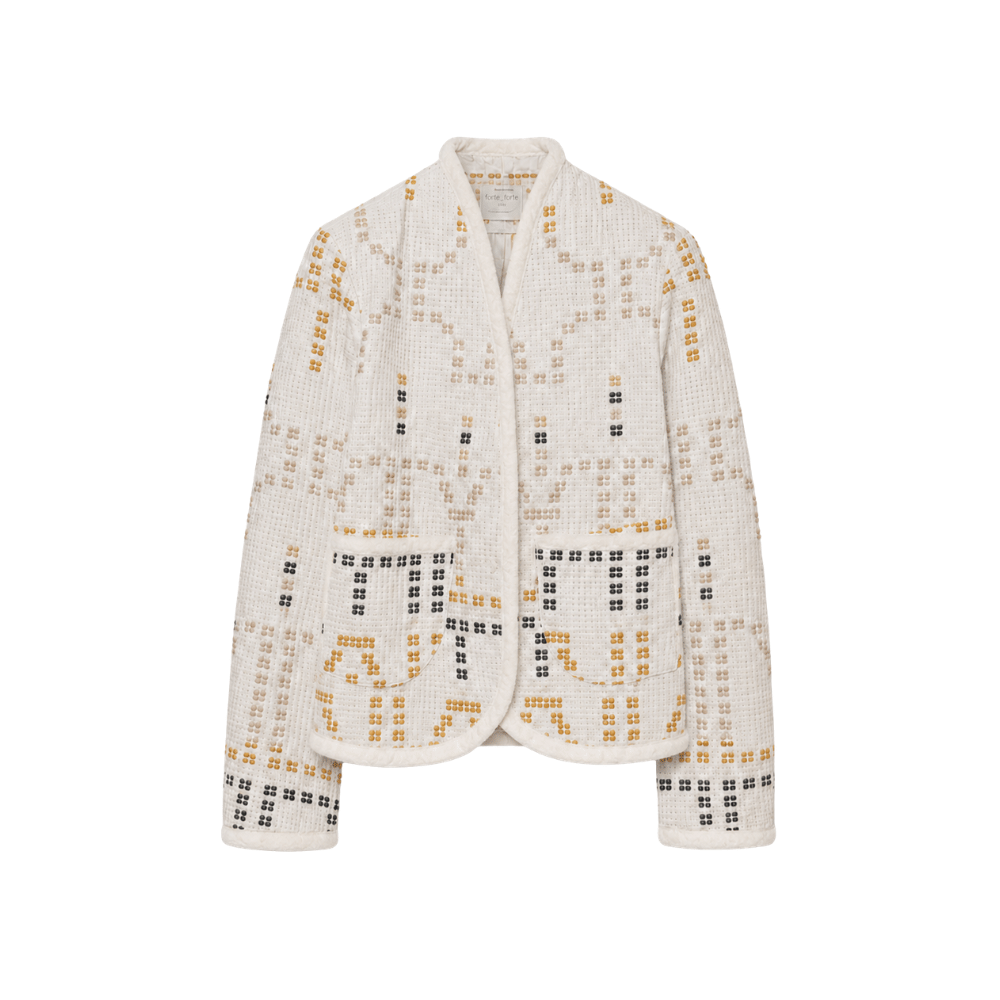 A cropped, long-sleeve cardigan jacket with a textured, waffle-like fabric, featuring a geometric grid pattern in black and mustard yellow on an off-white base. It has a stand collar and front pockets, shown against a plain white background.