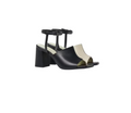 A pair of black and white stacked heel sandals with adjustable ankle straps and a silver metal buckle.