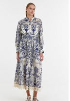A model wearing a long floral dress with full-length sleeves and a textured pattern. The dress features a blue and white color scheme with lace detailing at the hem.