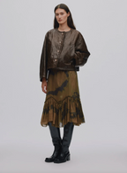 Woman wearing a brown jacket and skirt with black accents on a white background