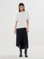 Woman wearing a white top and black skirt on a white background