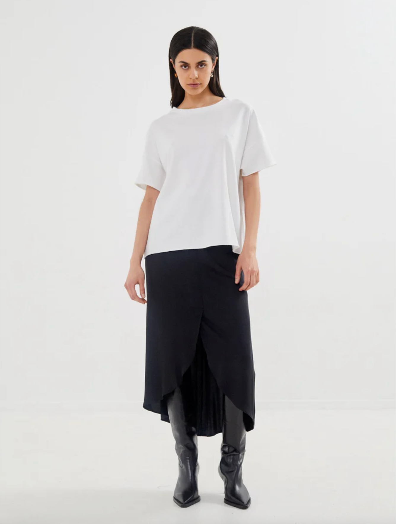 Woman wearing a white top and black skirt on a white background