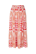 A high-waisted midi skirt featuring a vibrant orange and red ikat-style geometric pattern on a white base, shown against a light gray studio background.