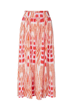 A high-waisted midi skirt featuring a vibrant orange and red ikat-style geometric pattern on a white base, shown against a light gray studio background.