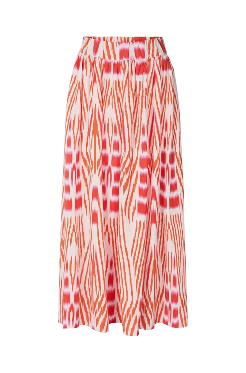 A high-waisted midi skirt featuring a vibrant orange and red ikat-style geometric pattern on a white base, shown against a light gray studio background.