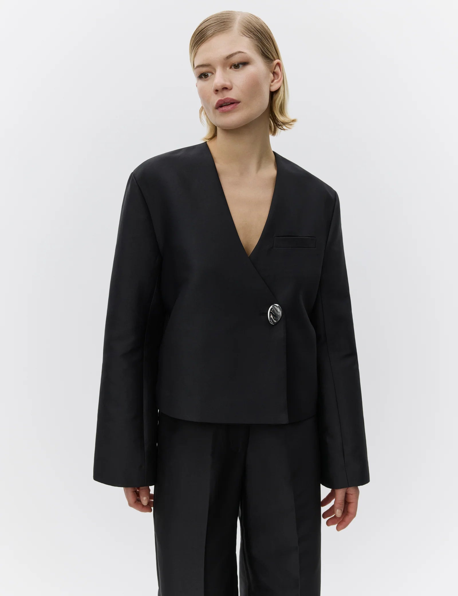 Woman wearing a black suit on a white background