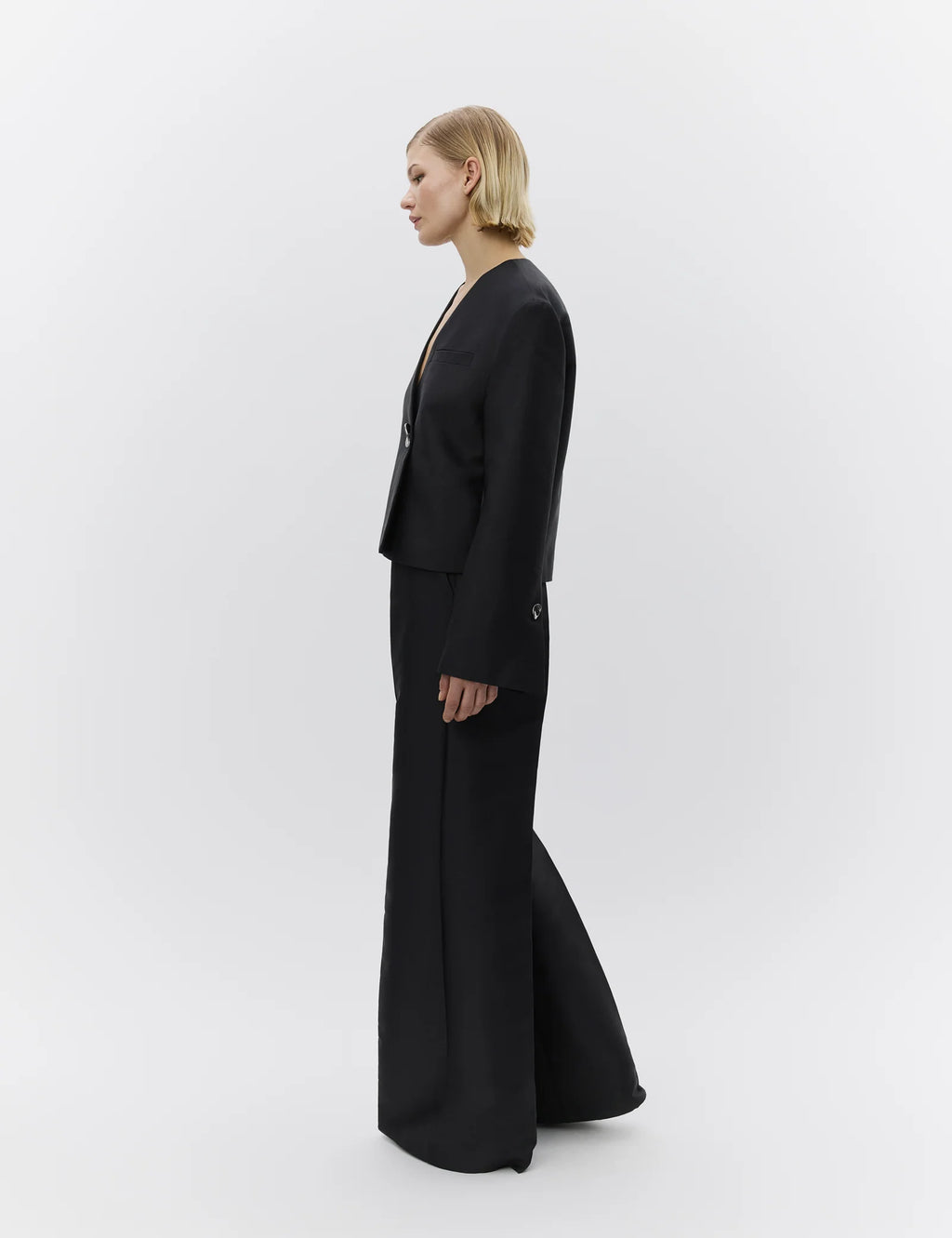 Person wearing a black suit on a white background