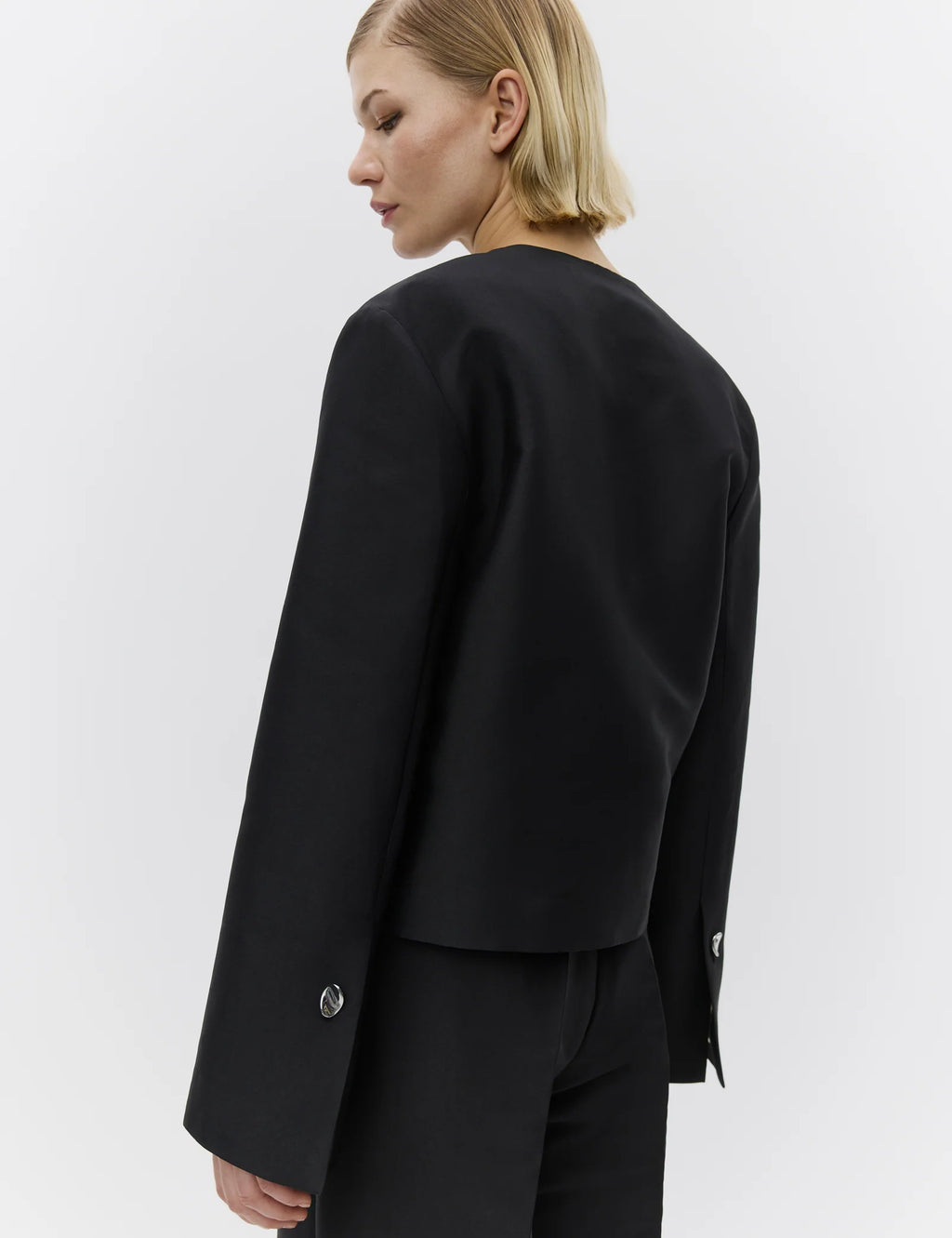Person wearing a black jacket on a white background