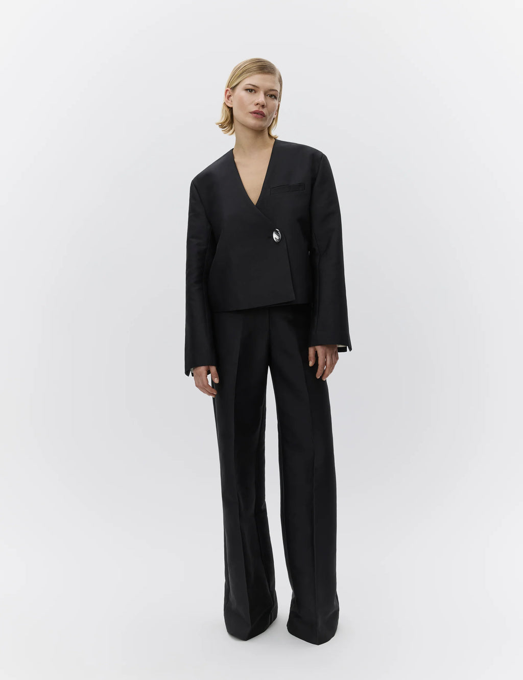Person wearing a black suit on a white background