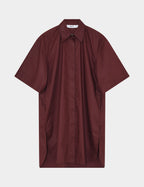 Maroon shirt with a draped front on a light gray background