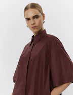 Woman wearing a brown shirt against a white background