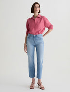 Woman wearing a pink shirt and light blue Brinley Crop Fiction AG jeans on a white background front side.shop online