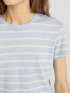 Close-up of a person wearing a light blue and yellow striped shirt against a neutral background