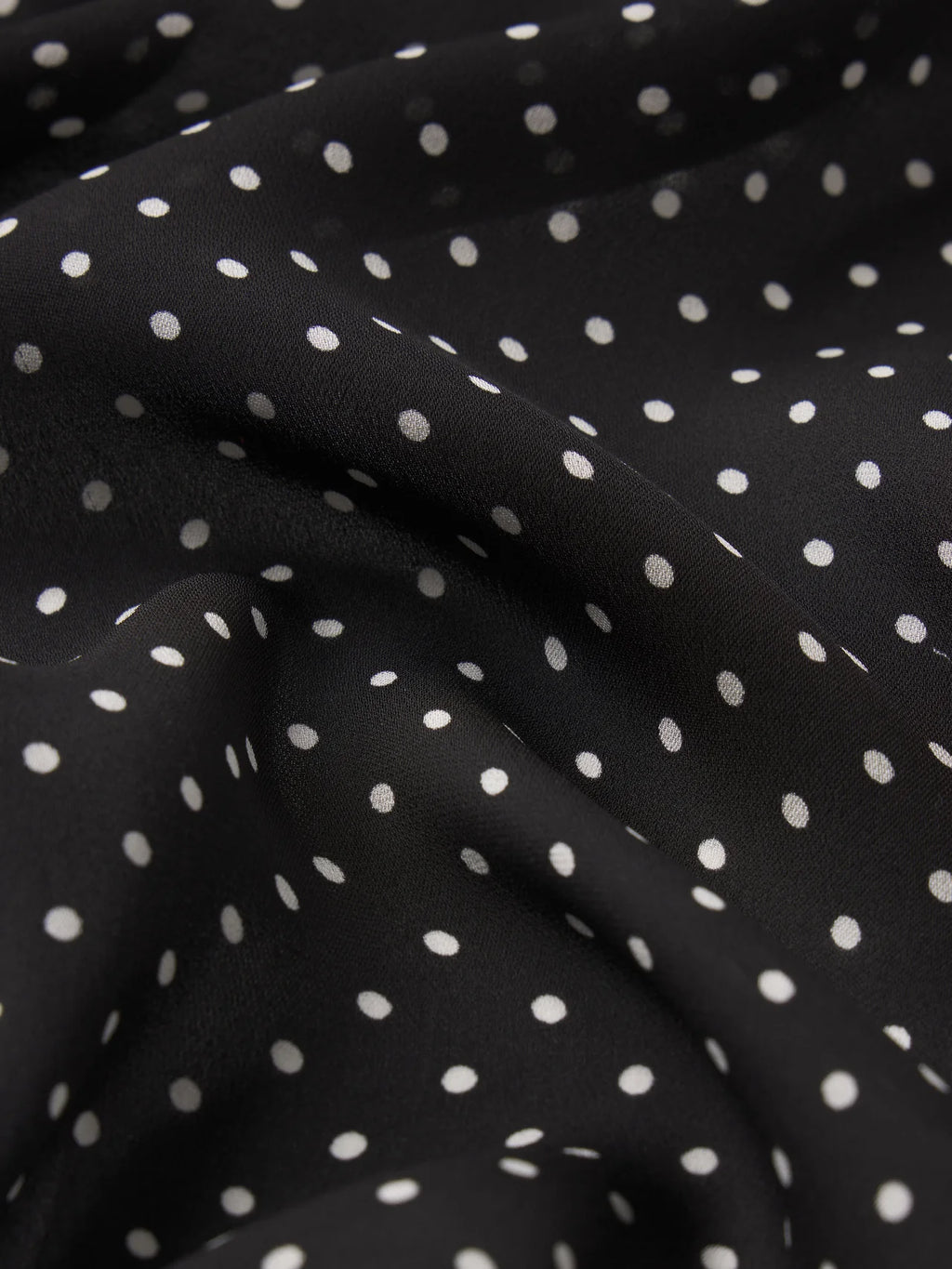 Black fabric with white polka dots