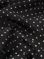 Black fabric with white polka dots