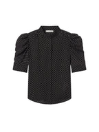 Black blouse with white polka dots on a light gray background. Gillian Top Blouse Frame brand
