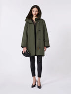 Woman wearing a green coat on a white background